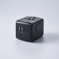 Universal travel adapter with two USB ports and a power outlet for worldwide use – compact multi-device charger